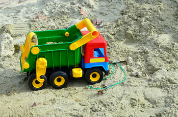 Children playing in the sandbox sandpit, kids with toy car vehicle, playground in kindergarten day...