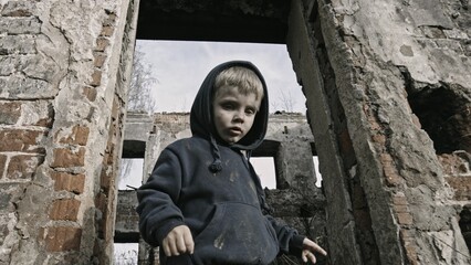Child playing war in ruins 