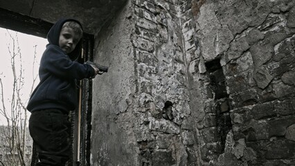 Obraz na płótnie Canvas Child playing war in ruins 