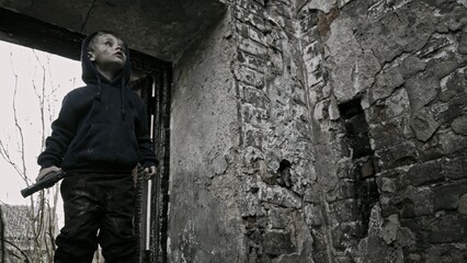 Child playing war in ruins 