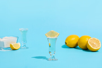 Shot of tasty tequila and lemon on color background