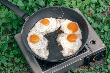 Scrambled eggs in a frying pan. Snack in nature. Appetizing food.