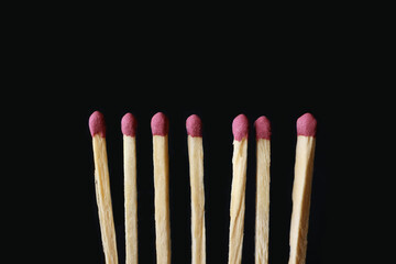 Line of unlit matches on black background