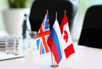 British, Russian and Canadian flags on table in office