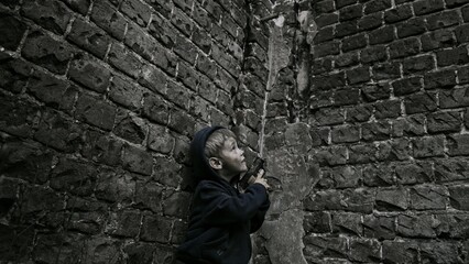 Child playing war in ruins