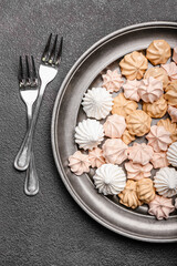 Plate with sweet meringue on dark background, closeup