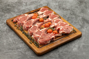 Lamb chops on dark background. Raw lamb chops on wood serving board