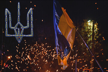 Ukrainian flag during a protest rally on Independence Square at night. The struggle of the...