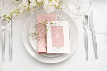 Stylish table setting with wedding invitation and gypsophila flowers - obrazy, fototapety, plakaty
