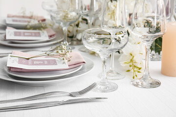 Stylish table setting with wedding invitations and gypsophila flowers
