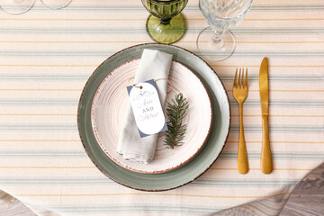 Stylish table setting with wedding invitation