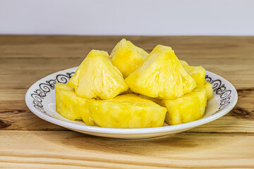 Sliced pineapple in  plate on wooden table close-up sweet and sour fruit nutritious and high in vitamins