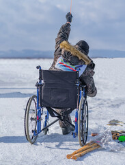 handicapped man fishing on ice.