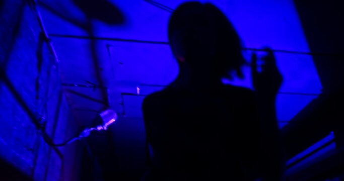 Slow motion low angle shot of scared victim running away from the pursuer. The witness of illegal fights is trying to hide in the dark corners of an underground club
