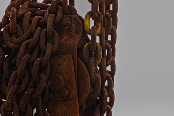 Stare , zardzewiałe , stalowe , łańcuchy ( z resztkami żółtej farby ) nawinięte na wielokrążek ( bloczek) , element mechanizmu dźwigu .  © Grzegorz
