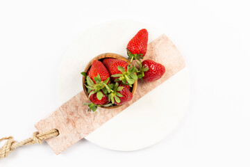 strawberries in bowl on marble on white background