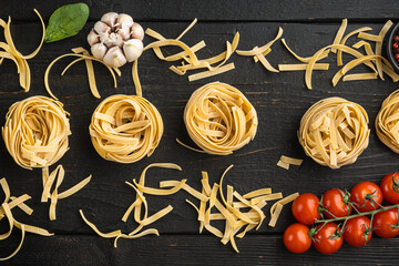 Fettuccine Tagliatelle pasta Italian food ingredients, on black wooden table background, top view flat lay