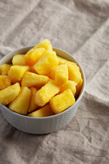 Organic Frozen Pineapple Slices in a Bowl, side view. Space for text.