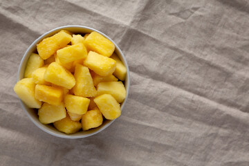 Organic Frozen Pineapple Slices in a Bowl, top view. Flat lay, overhead, from above. Copy space.