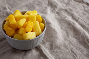Organic Frozen Pineapple Slices in a Bowl, side view. Copy space.