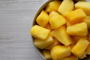 Organic Frozen Pineapple Slices in a Bowl, top view. Flat lay, overhead, from above. Space for text.