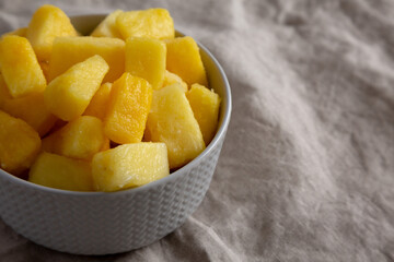 Organic Frozen Pineapple Slices in a Bowl, side view. Space for text.