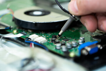 Obraz premium An electrician measures the voltage while repairing an LSD TV in a service center