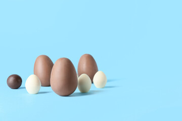 Different chocolate Easter eggs on blue background