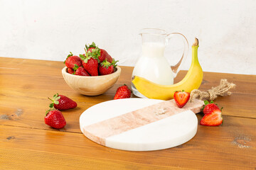 strawberries and bananas on the floor on the wooden table