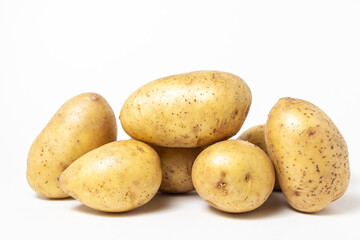 Young potatoes on a white background. Raw yellow potatoes. New crop