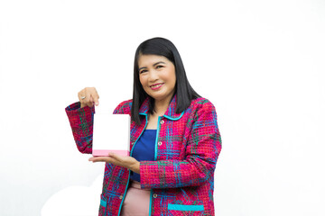 Close up cnfident middle-aged Asian woman wearing pink casual wear holding and pointing a white box on her hand on white background.