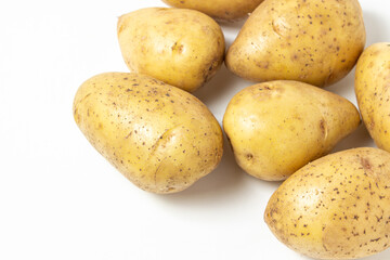 Young potatoes on a white background. Raw yellow potatoes. New crop