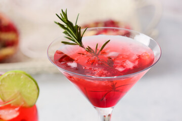 Glass of tasty pomegranate cocktail on light background, closeup