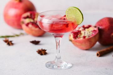 Glass of tasty pomegranate cocktail on light background