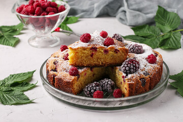 Homemade blackberry and raspberry pie, with piece on plate on light gray background, horizontal format