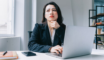 Portrait of young Asian woman thinking