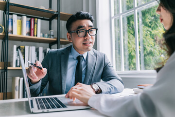 Two Asian businesspeople working at office