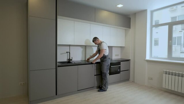 The builder checks the dimensions and quality of installation of the kitchen furniture structure