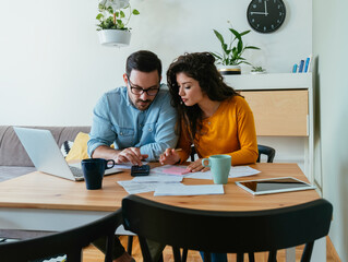 Serious Couple Paying Bills at Home. 
Stressed man and woman talking about family budget and...