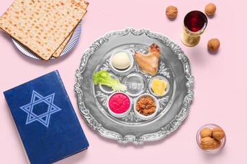 Passover Seder plate with traditional food and Torah on color background, top view