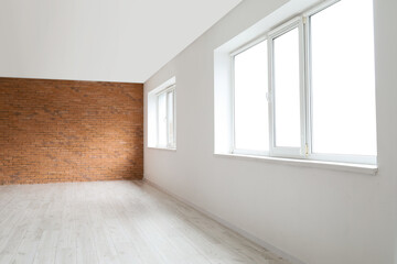 View of big empty room with windows, light and brick walls