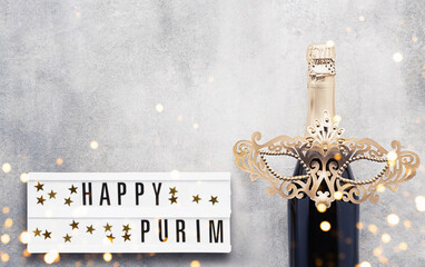 Purim background. Champagne and carnival mask on a gray background. Carnival concept. Top view,...