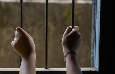 The child's hand was imprisoned in a cage. Indicates the deterioration of society, severe and depressing.