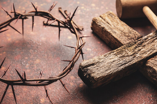 Crown of thorns with wooden cross on color background