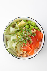 Poke bowl with salmon. Hawaiian cuisine. Healthy food with Omega 3. A dish in a deep bowl.Healthy food. Healthy lifestyle.Lean menu. Isolated object. White background.Copy space.Top view. Copy space.