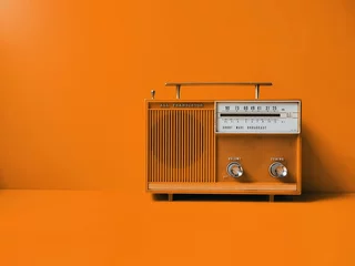Gordijnen Old transistor radio, orange wall background. Listen music concept © r5.retro