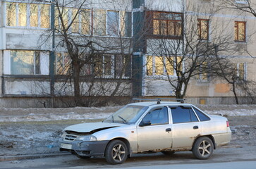 Naklejka premium An old light broken rusty car is parked on the street, Iskrovsky Prospekt, St. Petersburg, Russia, March 2022