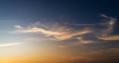 Naklejka na ściany i meble sunset sky in the evening with orange sunlight clouds on dark blue, dusk sky background 