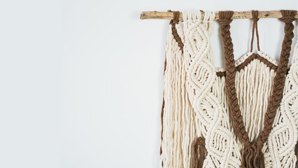 Wall panel in the style of Boho made of cotton threads in natural color using the macrame technique for home decor. close up