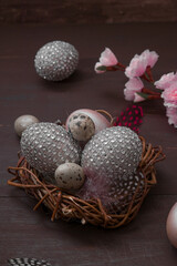 Happy Easter nest with eggs on a wooden background. Happy Easter greeting card with creative easter eggs and blossom cherry